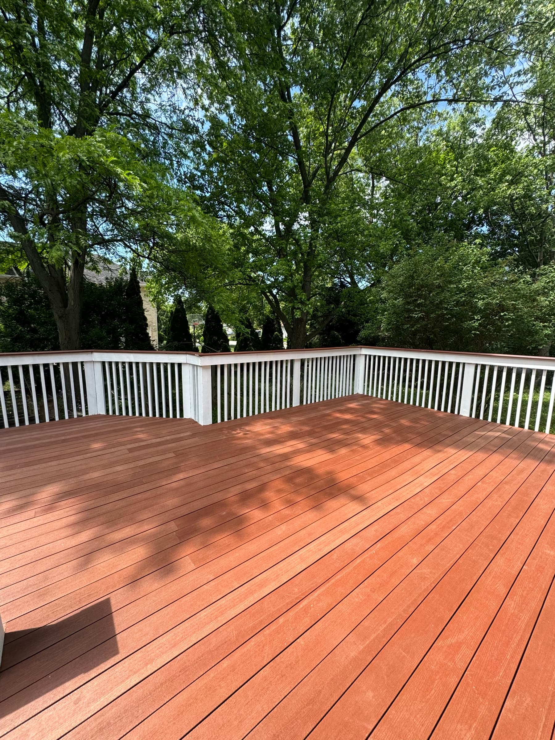 The rebuilt deck finished in a deep red-brown stain