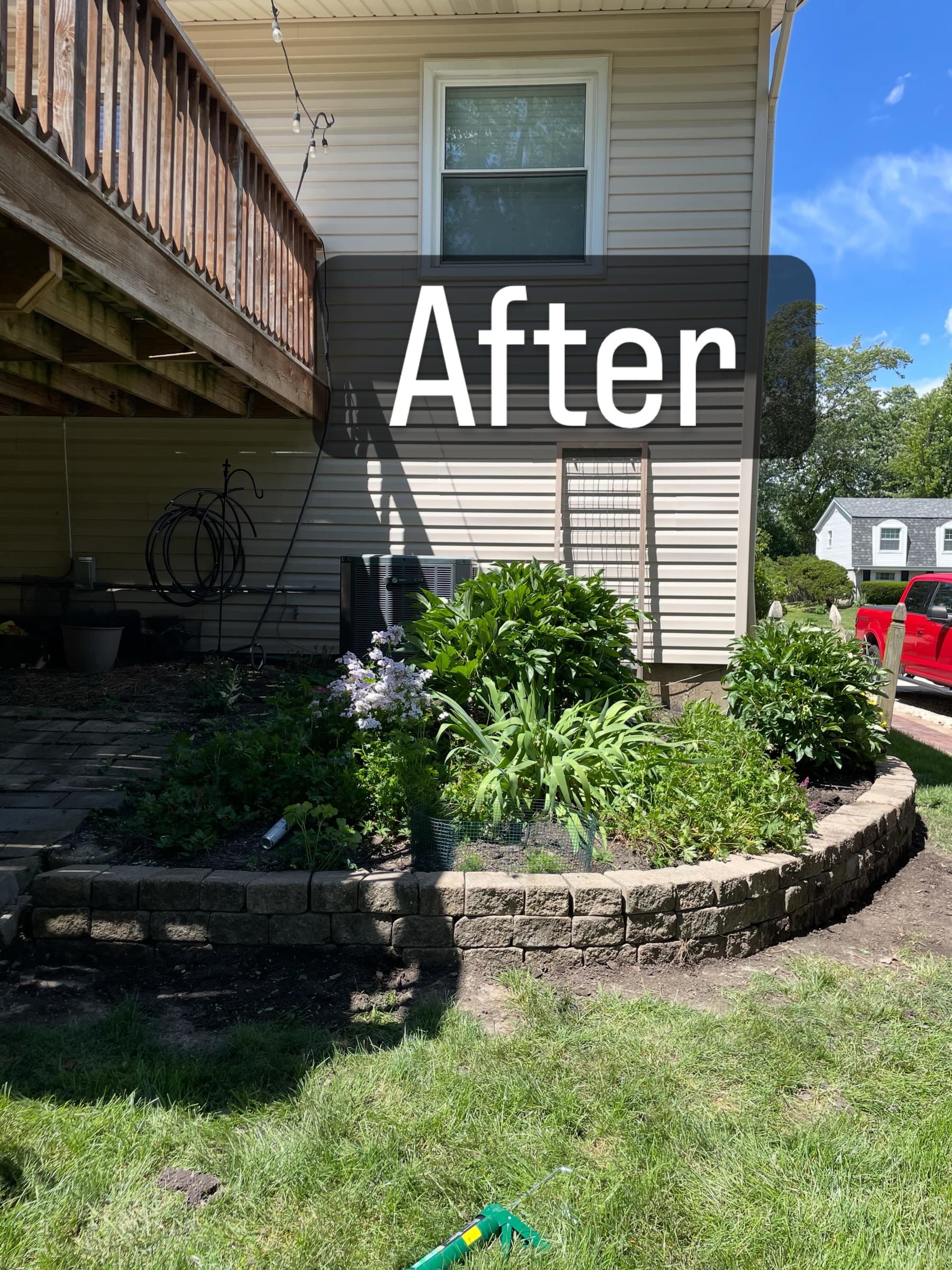 The same bed rebuilt with new stone edging and full planting