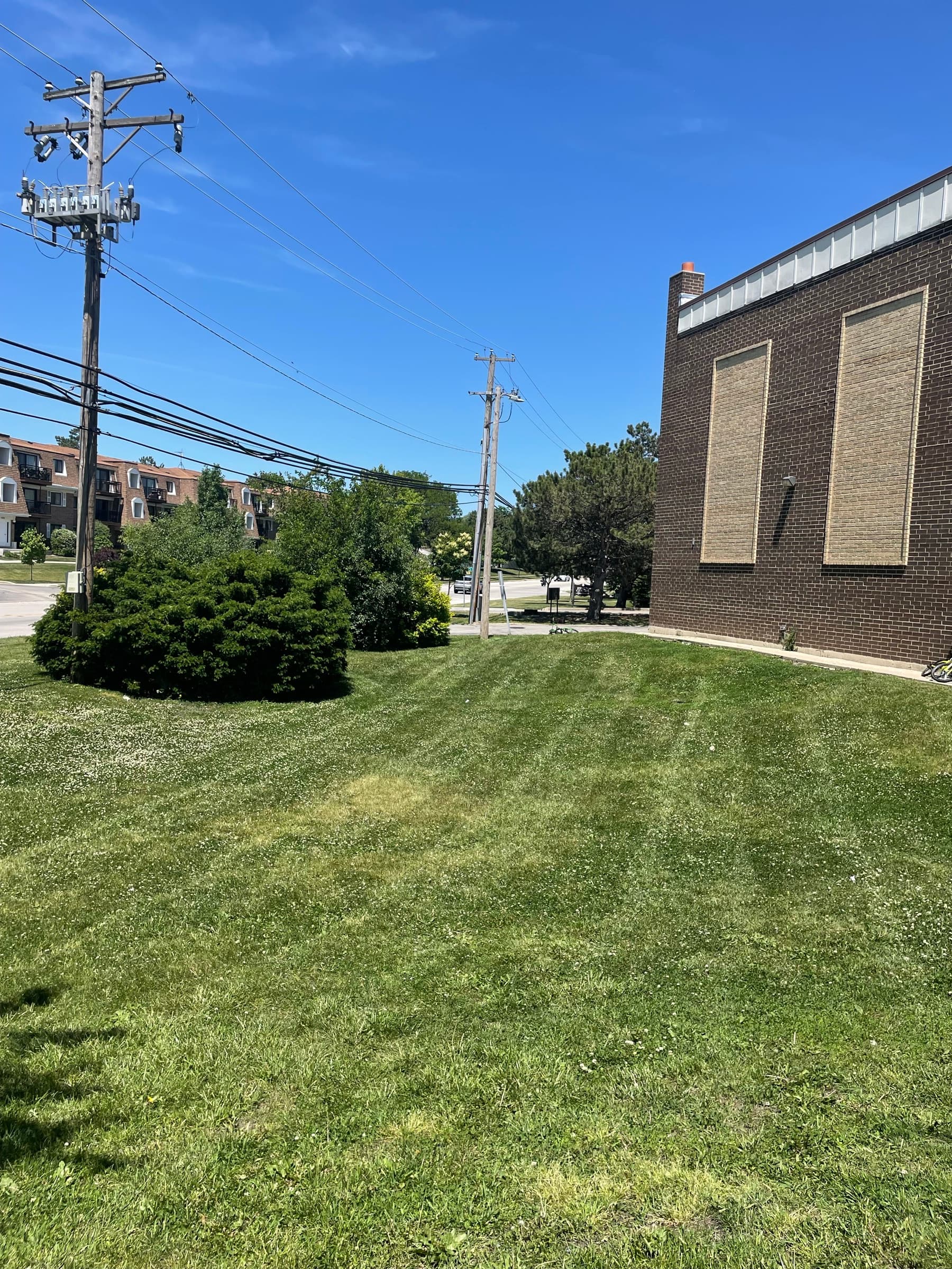 Commercial lawn beside a brick building cut in even stripes