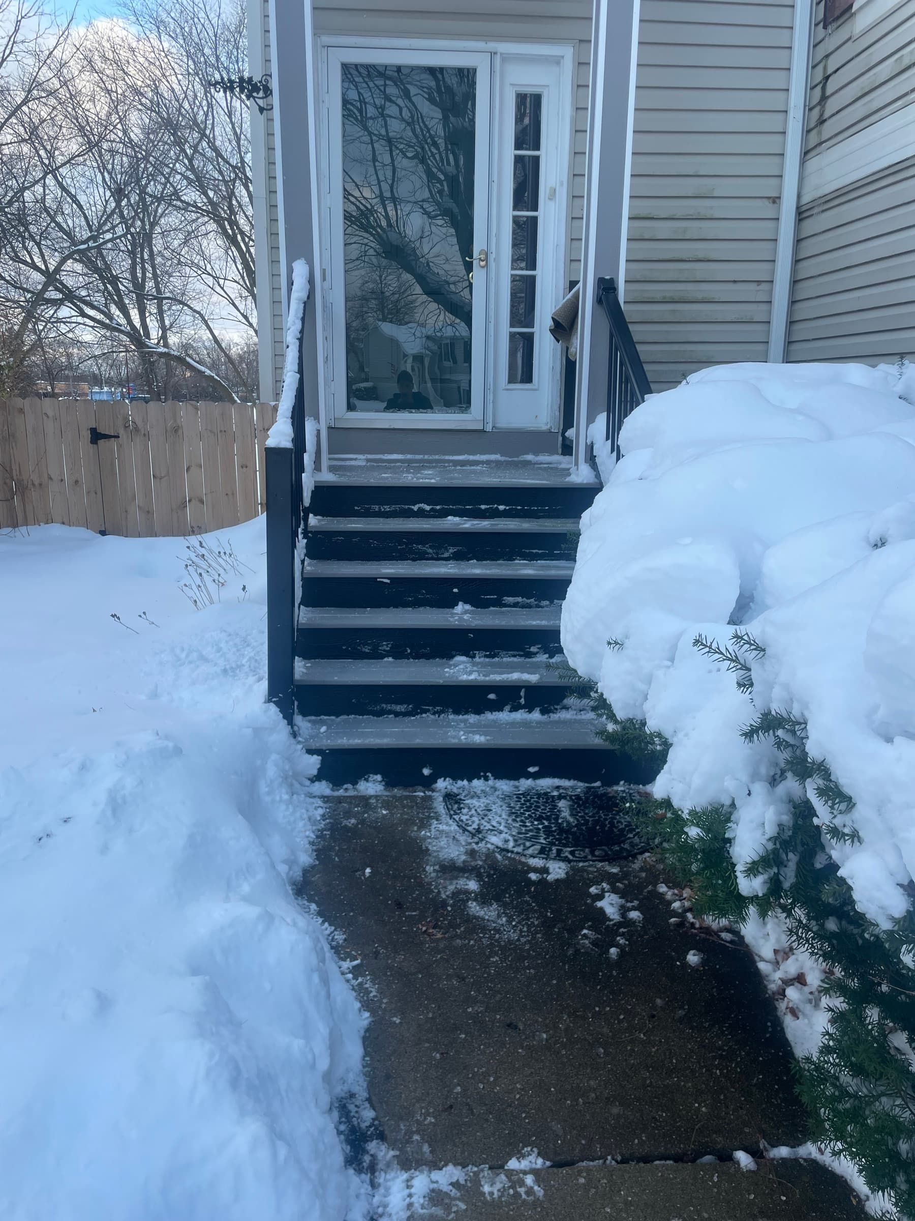 Front steps and walk shovelled clean to bare concrete between deep snow